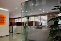 an office with a glass wall and plants